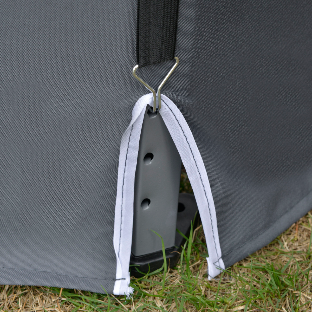 Close-up of a gray bag with a strap and buckle on grass